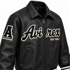 Three-quarter front view of Avirex men’s black leather jacket with Avirex New York lettering, sleeve patch and zip closure
