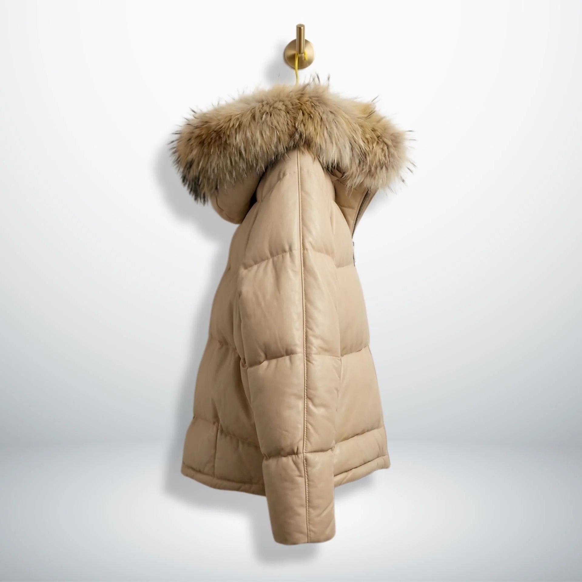 Side profile of beige leather puffer winter coat with fur hood.