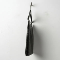Side profile of black croc leather mini skirt showing slim silhouette