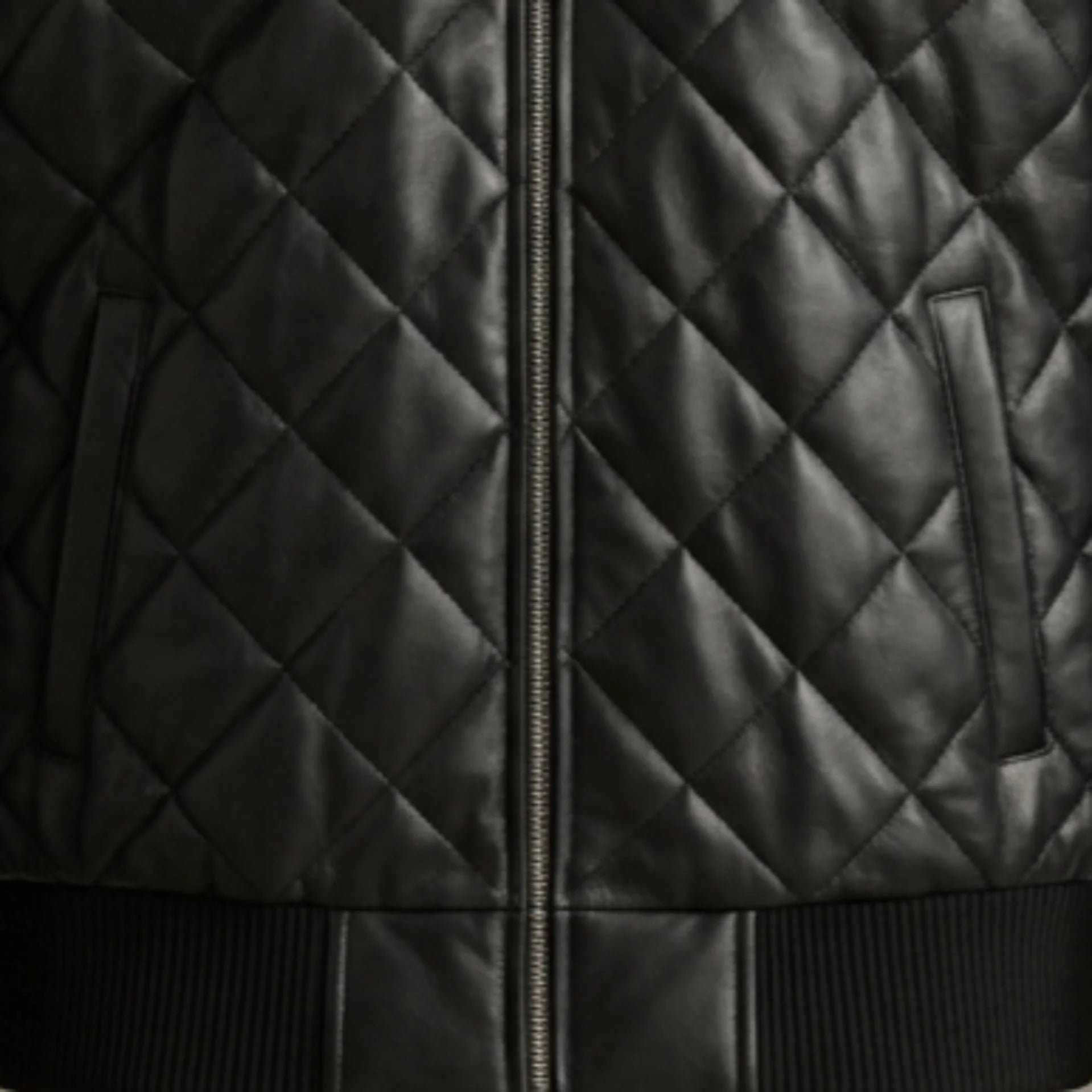 Close-up of functional pockets and heavy-duty zipper on black hooded leather bomber jacket