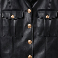 Close-up of gold buttons and flap pockets on black military leather jacket