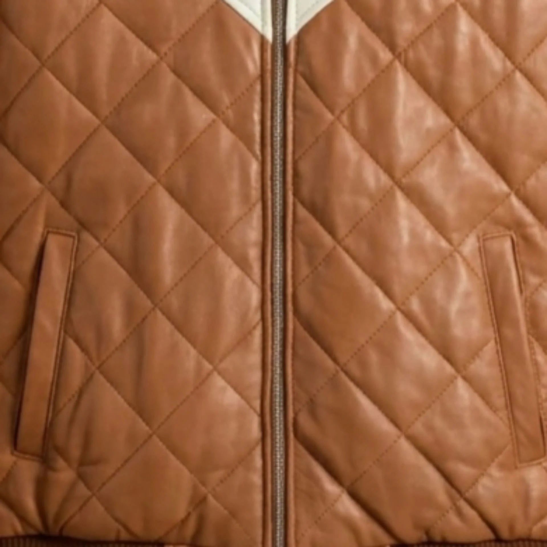Close-up of functional pockets and heavy-duty zipper on brown hooded leather bomber jacket