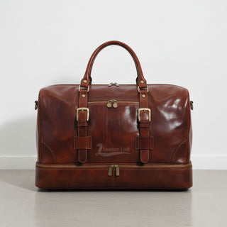 front view brown leather drop bottom duffle bag with buckles and front zip pocket by Leather Unit.