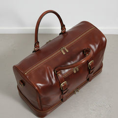 top angle of brown leather duffel bag with double zip closure and front pocket.