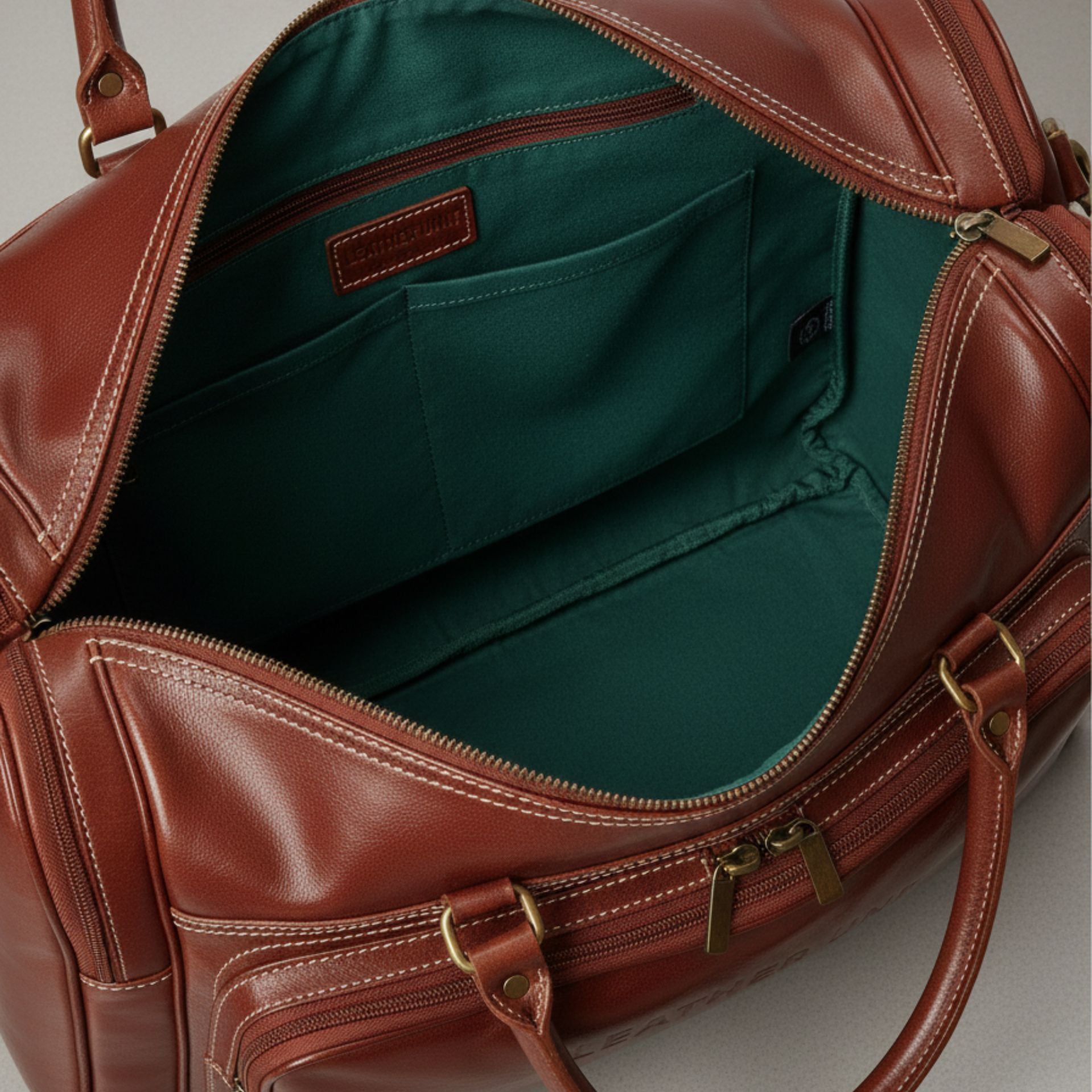interior of brown leather duffle bag with fabric lining and zip pocket.