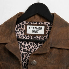 Close-up of collar and Leather Unit label on brown fringe leather jacket