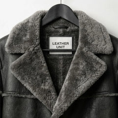 Close up of grey shearling collar and Leather Unit label on men’s coat