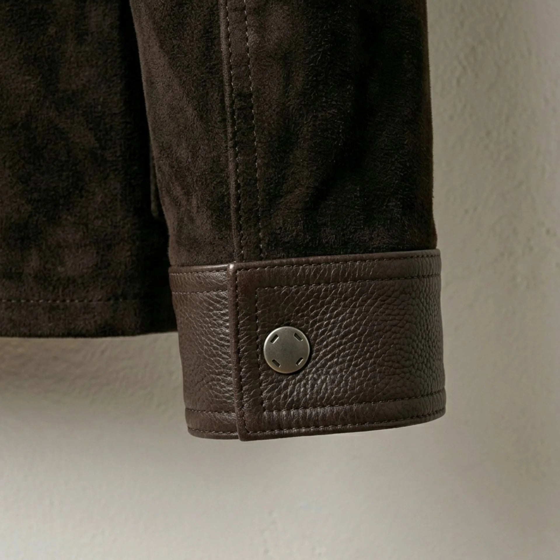Leather cuff with snap-button detail on men's brown suede trucker jacket