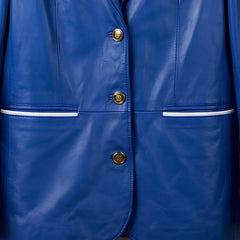 Gold front buttons and white pocket piping on women’s blue leather blazer