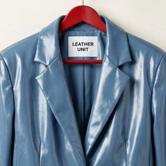 Close up of notched lapels and Leather Unit label on blue leather blazer