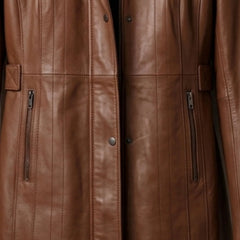 Zip pockets and front closure detail on women’s long brown leather coat