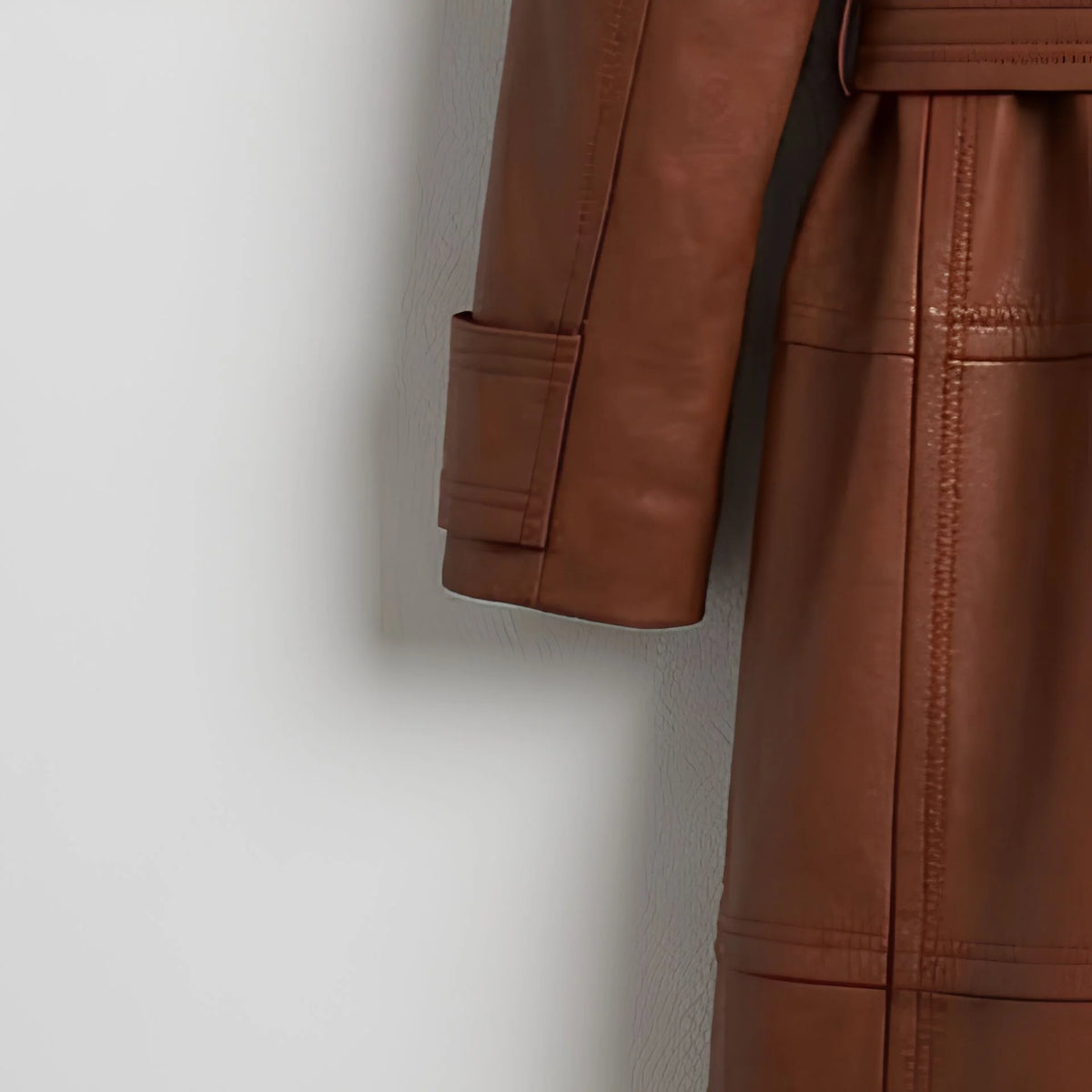 Sleeve cuff and stitching detail on women’s brown leather trench coat