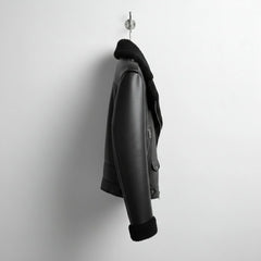 side profile mens black shearling aviator jacket hanging on wall.