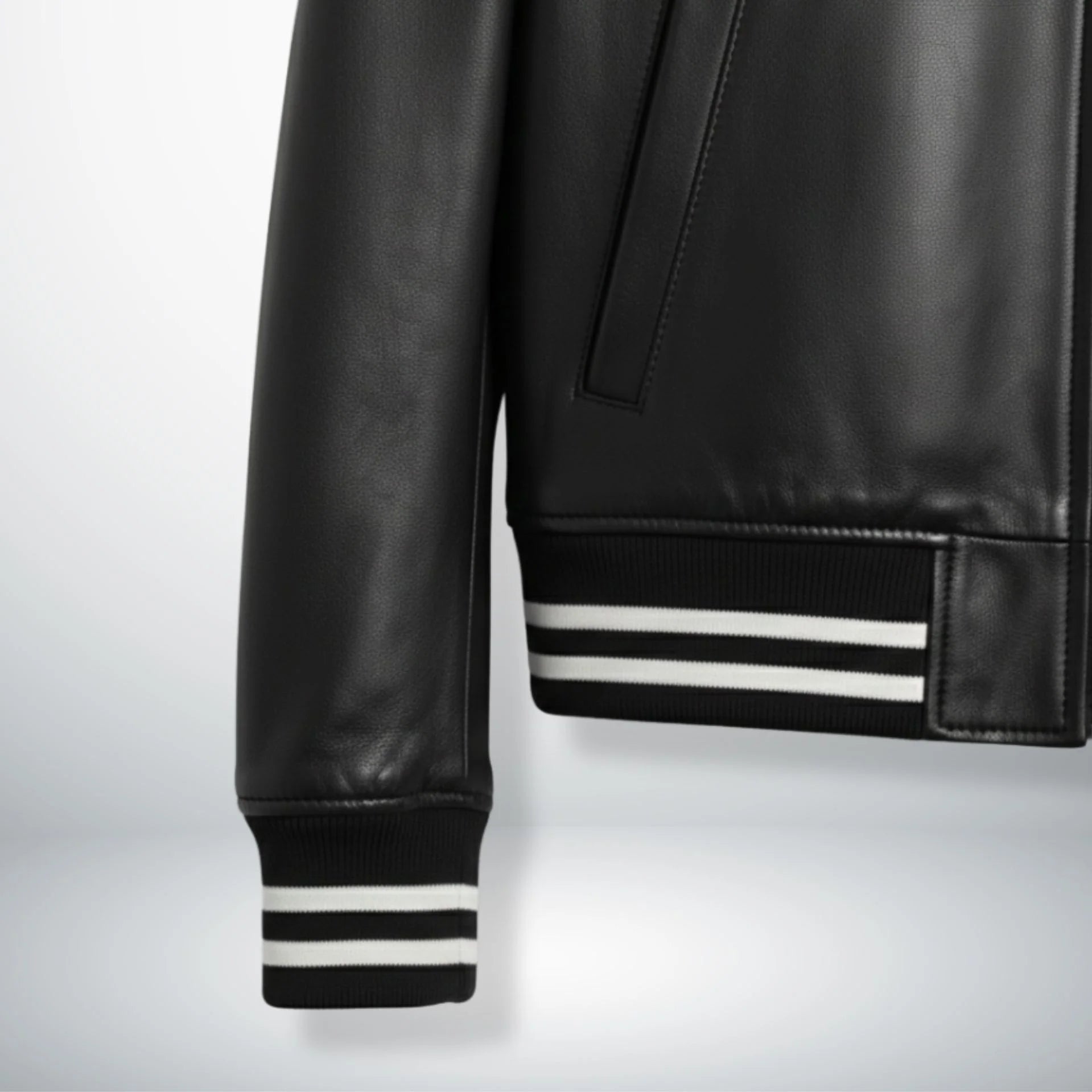 close up striped ribbed cuff and hem on black leather bomber jacket.
