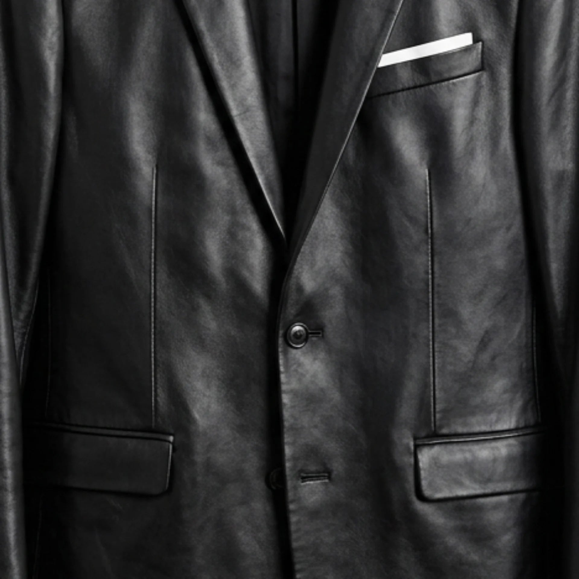 Two‑button front and flap pockets on men’s black leather blazer jacket