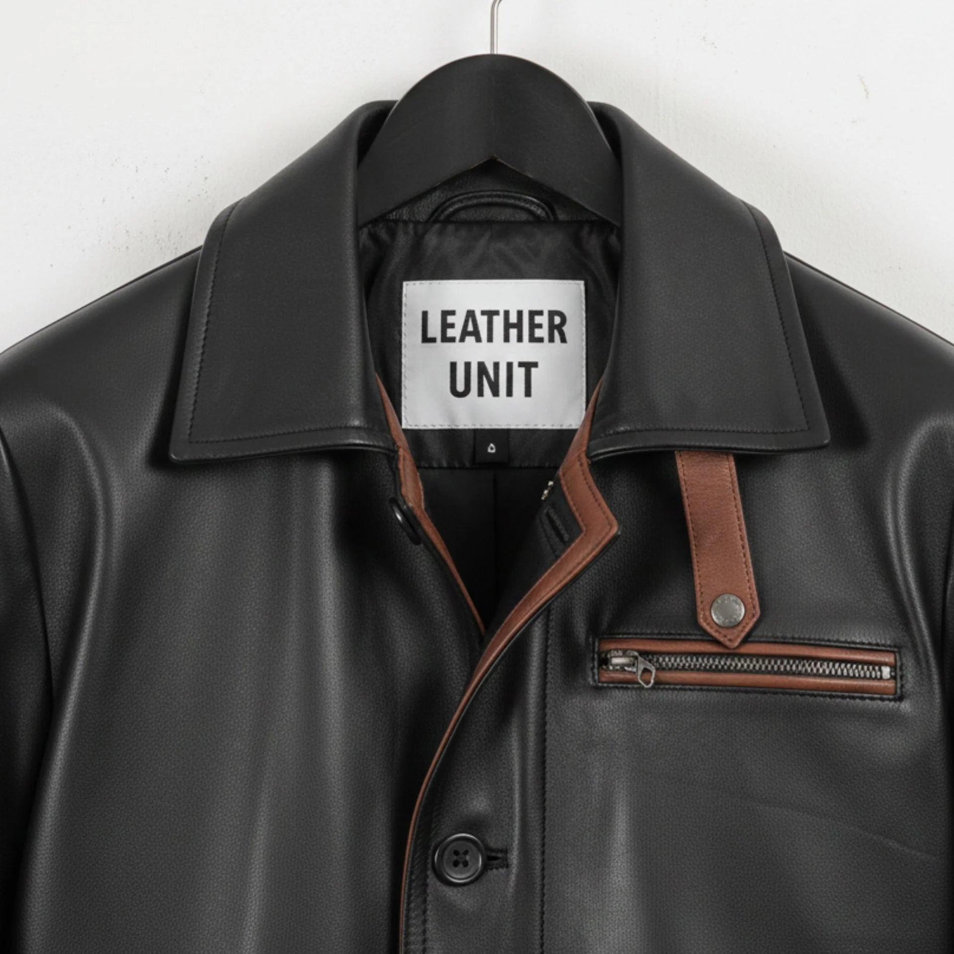 Close up of collar, Leather Unit label and brown strap on black leather coat
