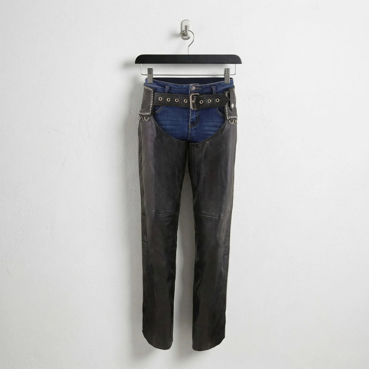 Front view of men's black leather motorcycle chaps with studded belt worn over blue jeans