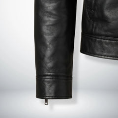 Detail of zippered cuff and hem stitching on men's black genuine leather biker jacket.
