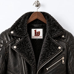 Close-up of black faux fur biker collar, textured sheepskin leather, snap details and metal chest zipper