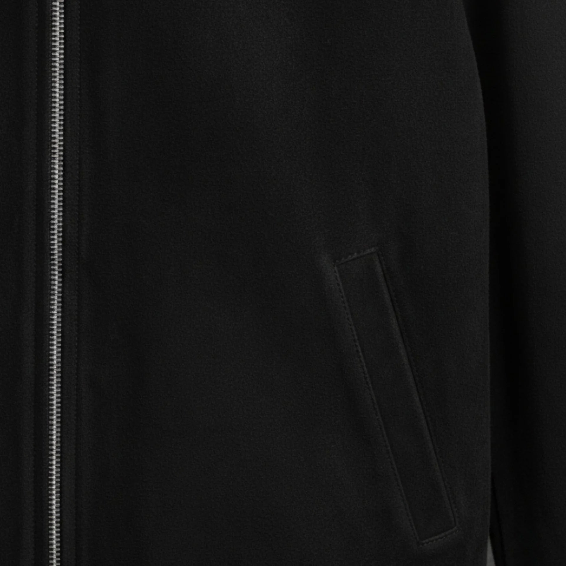 close up welt pocket detail on black suede bomber leather jacket.