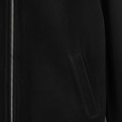 close up welt pocket detail on black suede bomber leather jacket.