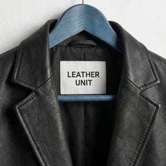 Close up of notch lapel and Leather Unit label on black leather blazer