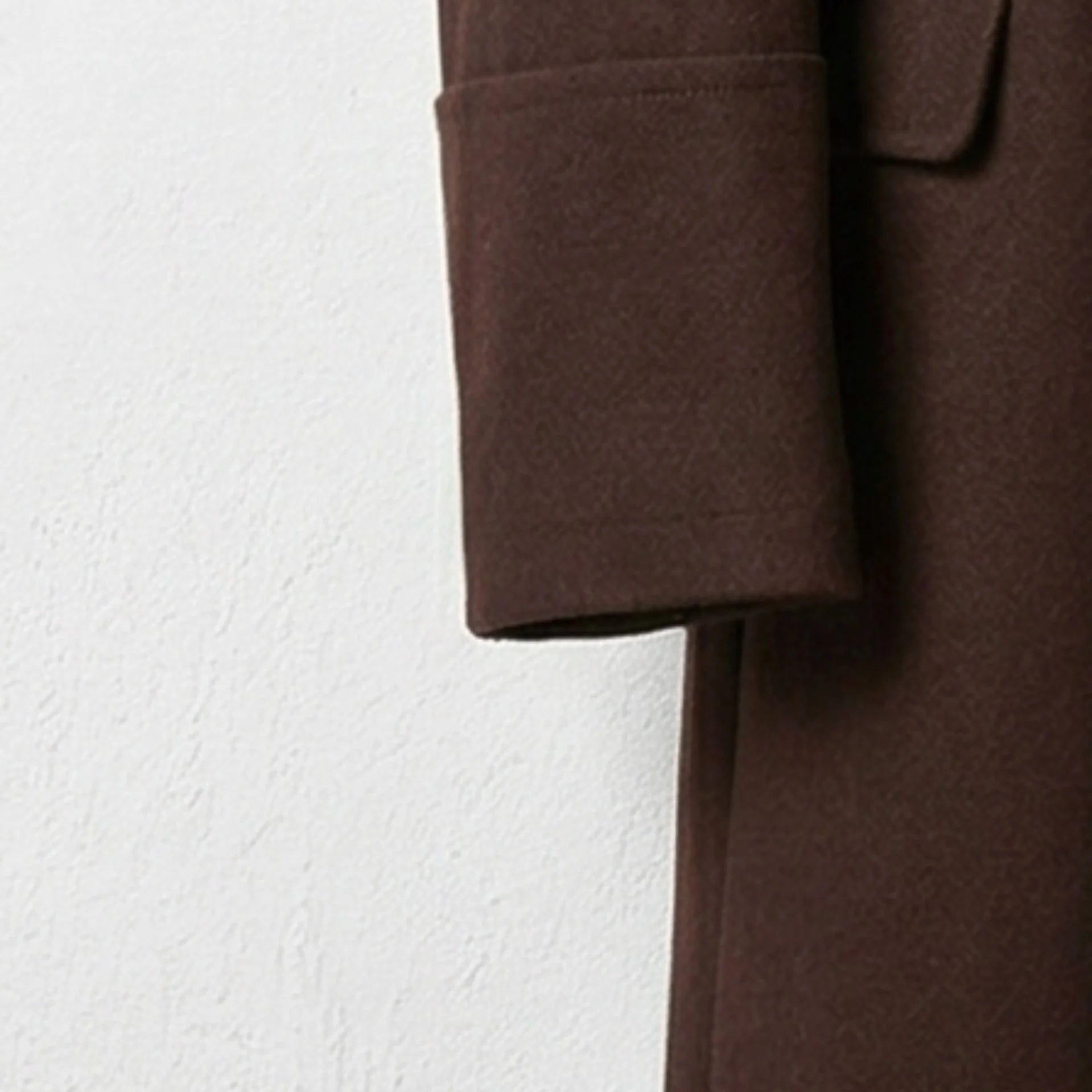 Detail of sleeve cuff on men's brown wool winter overcoat.
