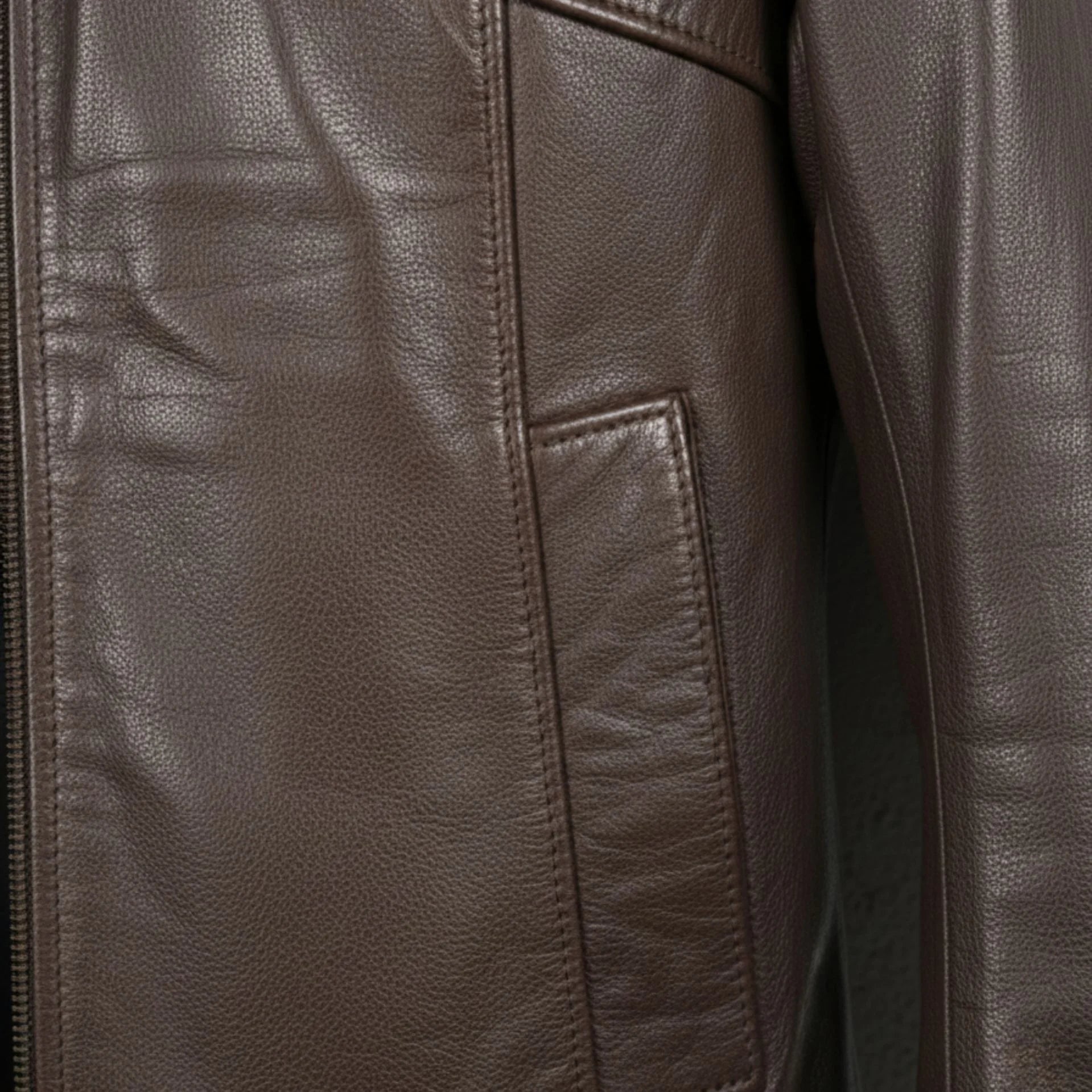 close up of pocket and leather grain on men's chocolate brown leather jacket.