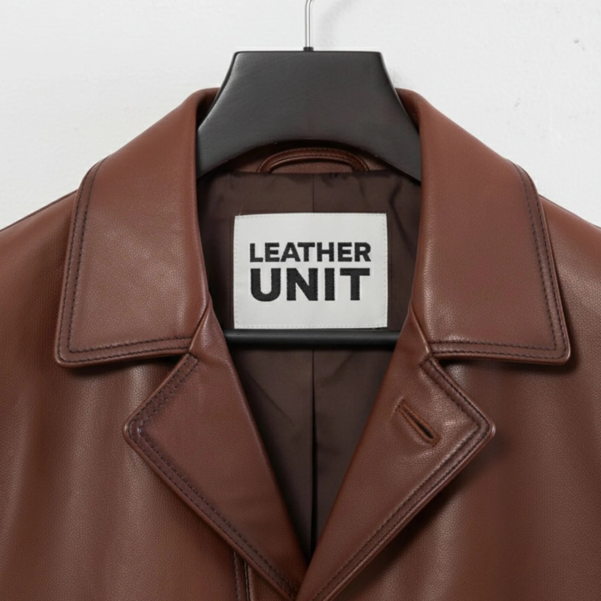Close up of lapel collar and Leather Unit label on brown leather blazer