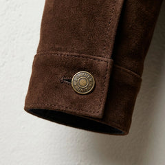 Detail of cuff with branded Leather Unit snap button on brown suede jacket.