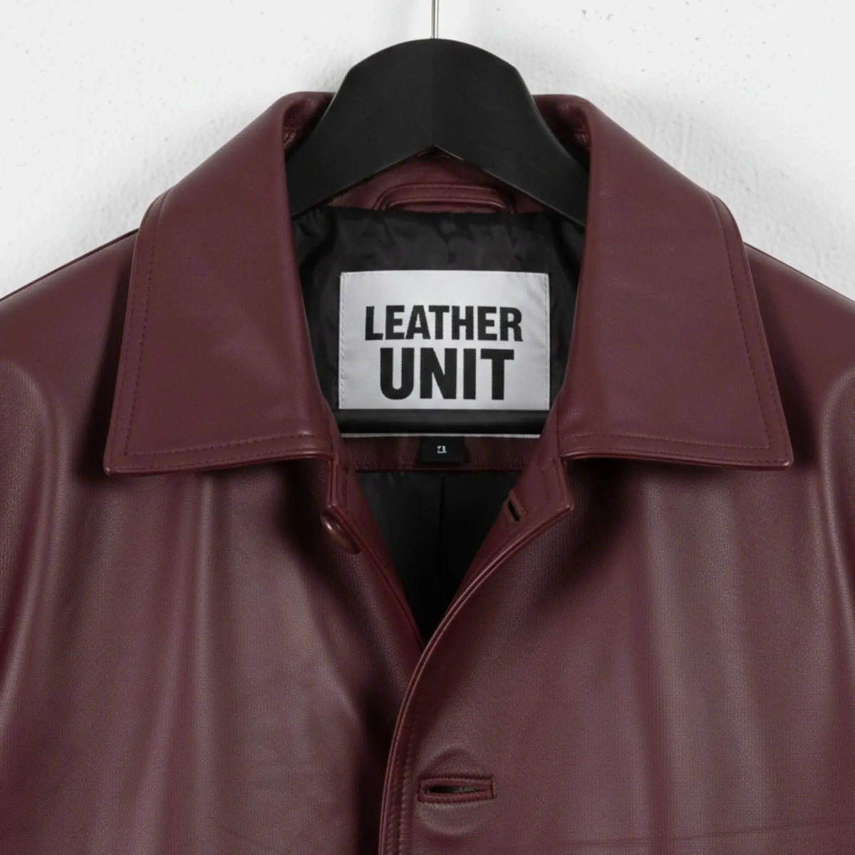 Close up of collar and Leather Unit label on burgundy leather coat