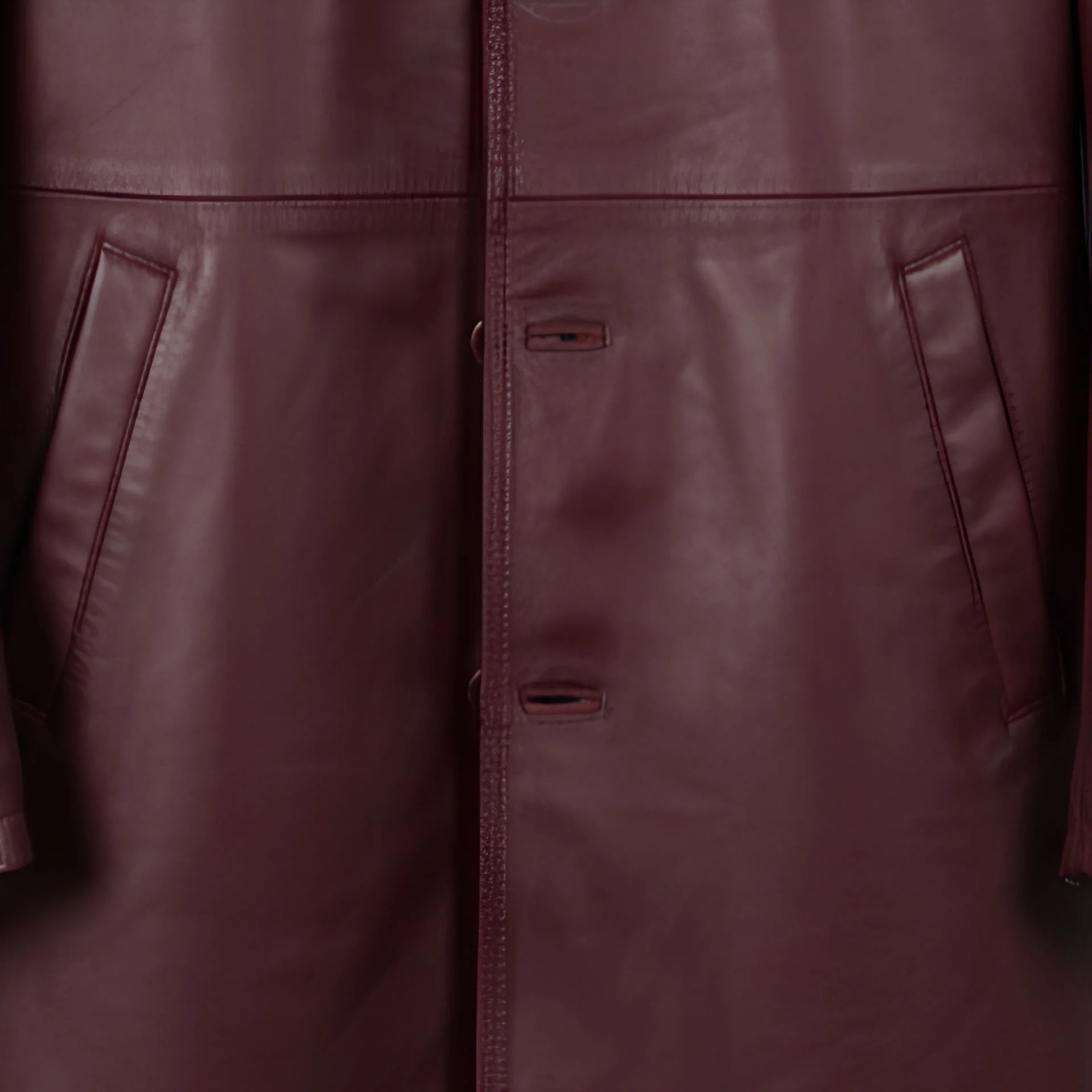 Front button placket and pocket detail on men’s burgundy leather jacket