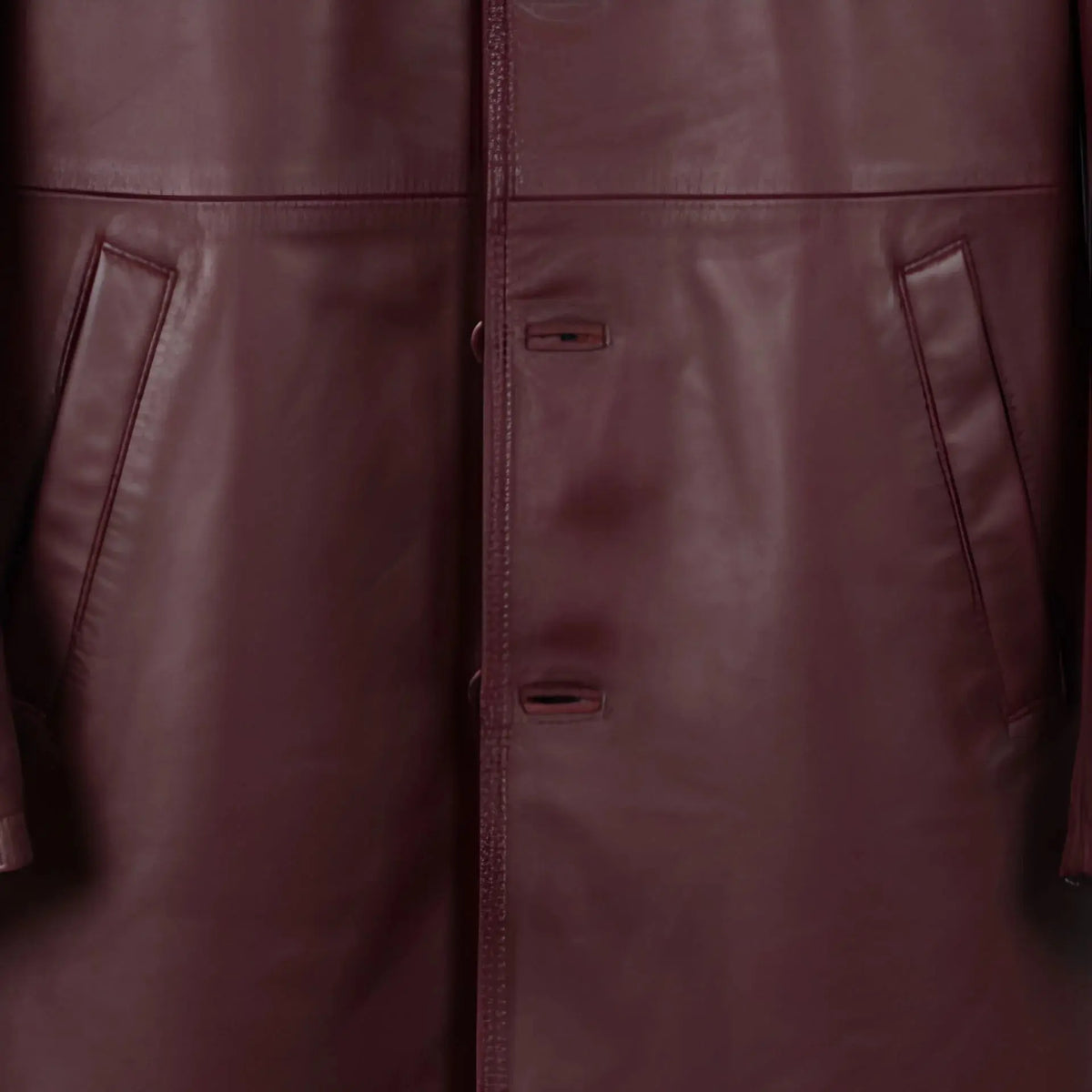 Front button placket and pocket detail on men’s burgundy leather jacket
