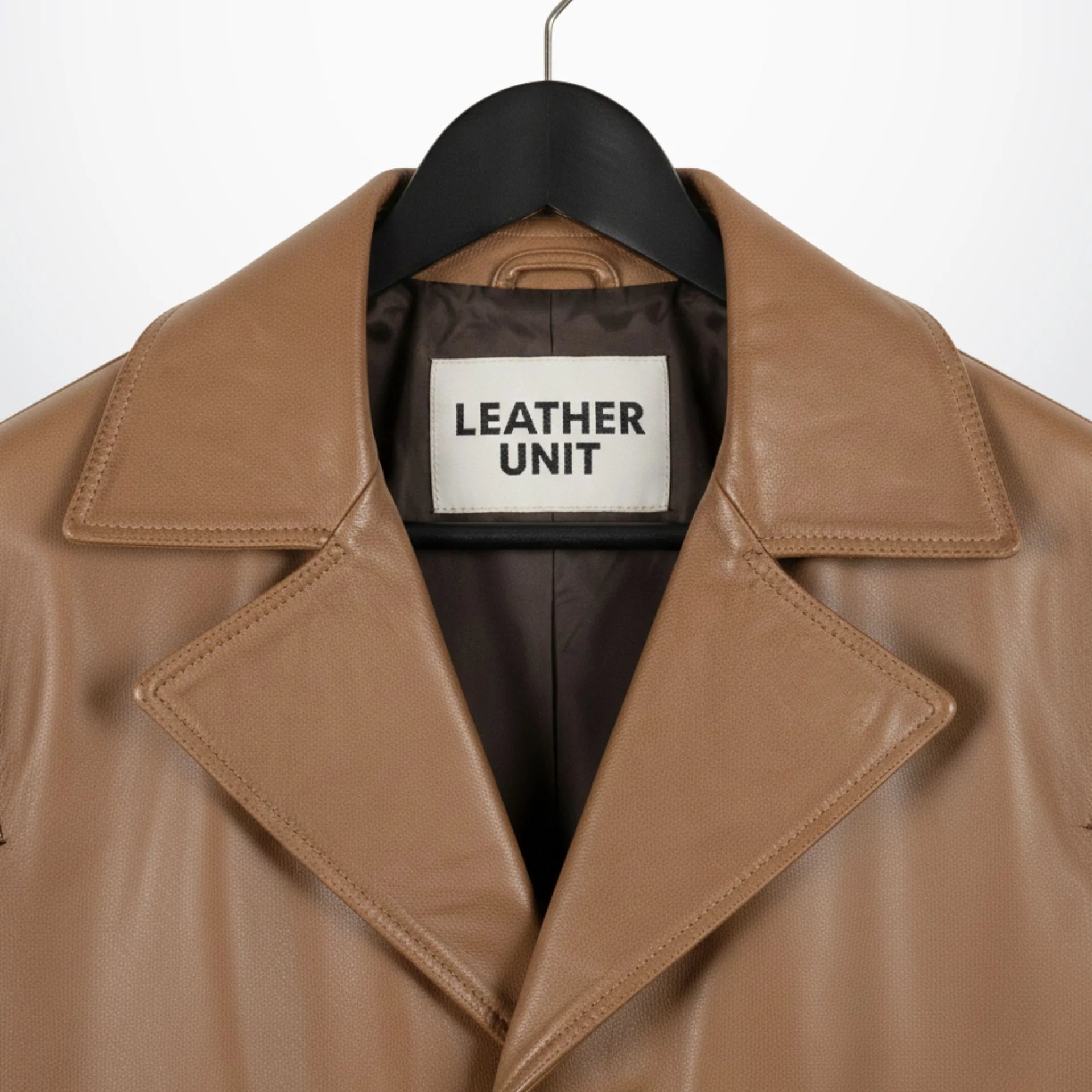 Close up of wide notch lapel and Leather Unit label on camel leather coat.