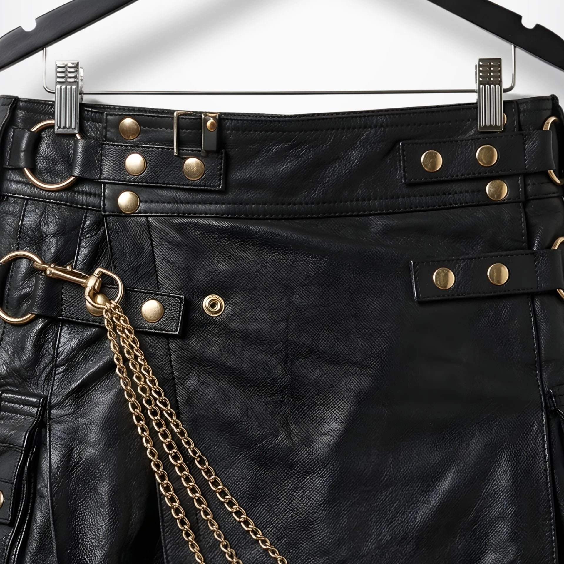 Close-up of waistband straps, buckles and gold hardware on black leather kilt
