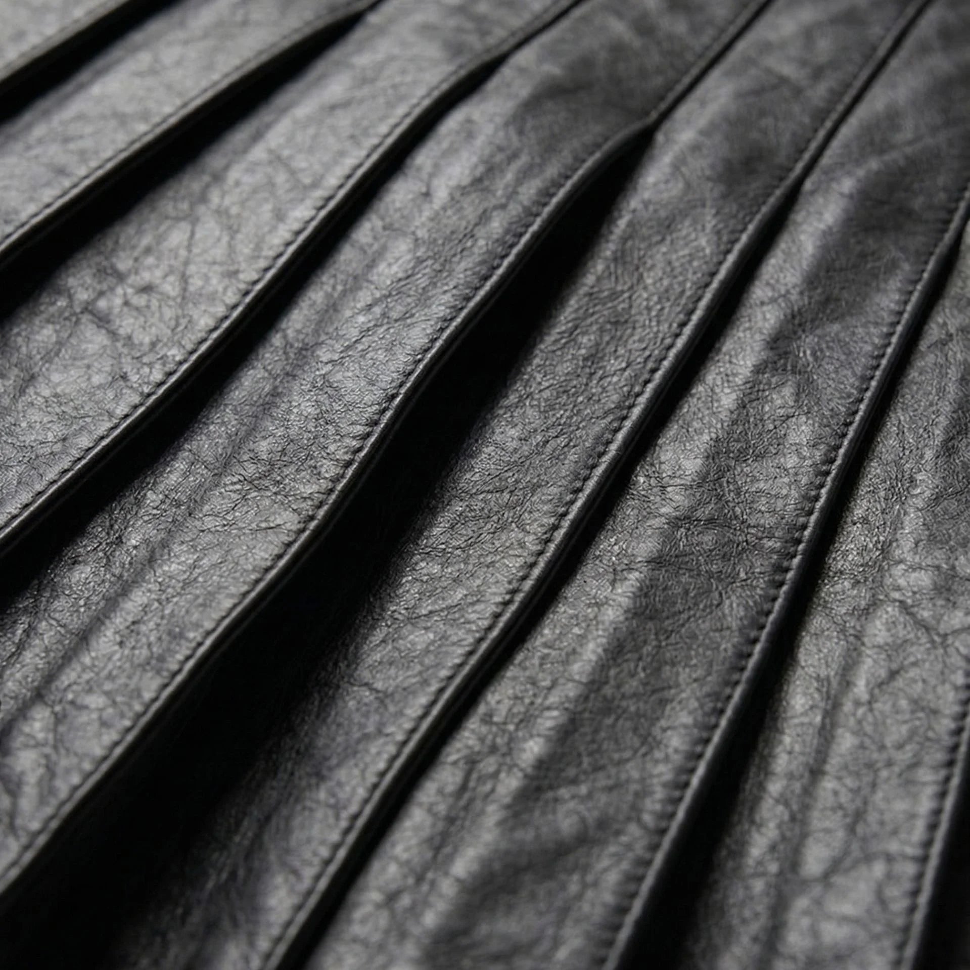 Detail of pleated black leather panels on gothic kilt