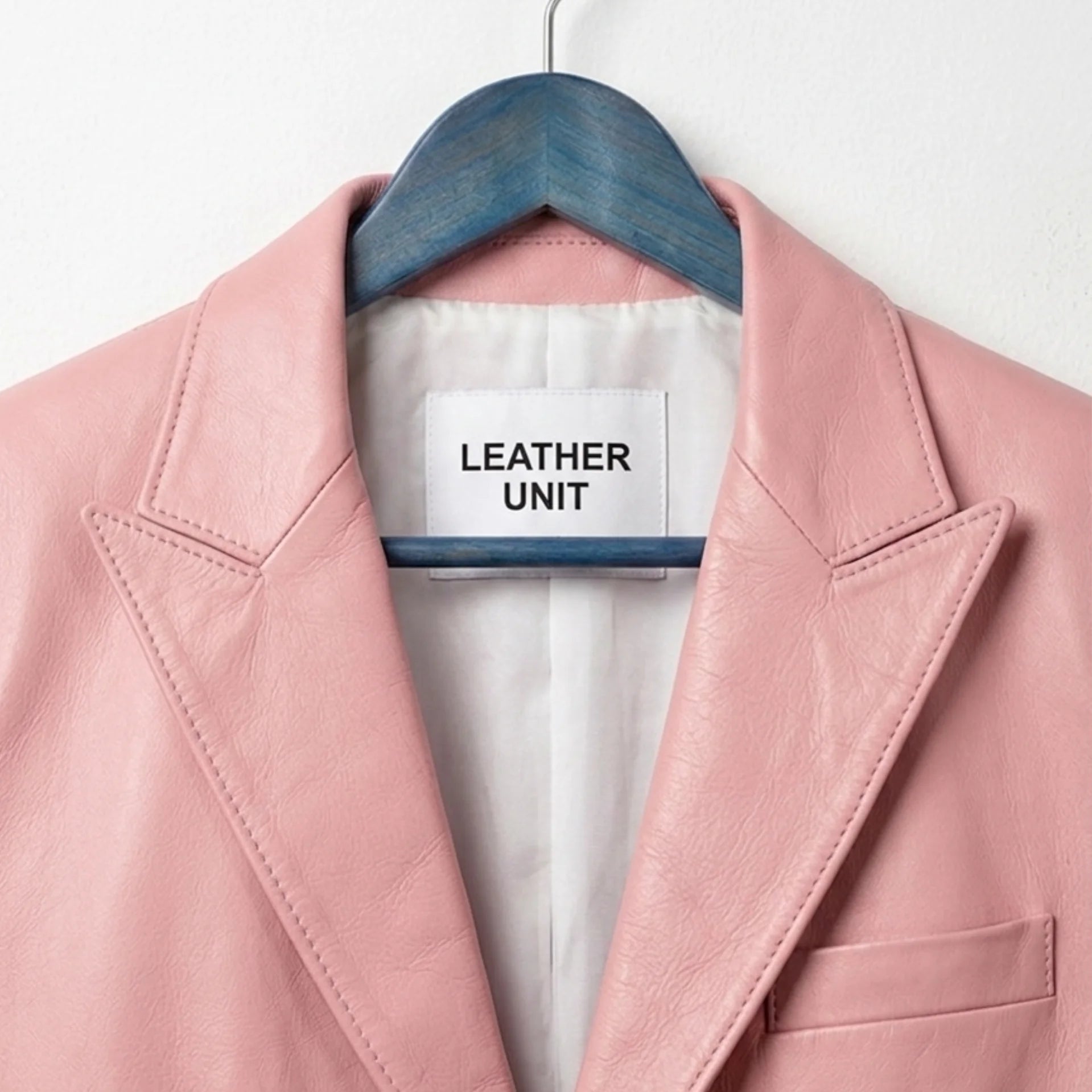 Close up of notch lapel and Leather Unit label on light pink blazer