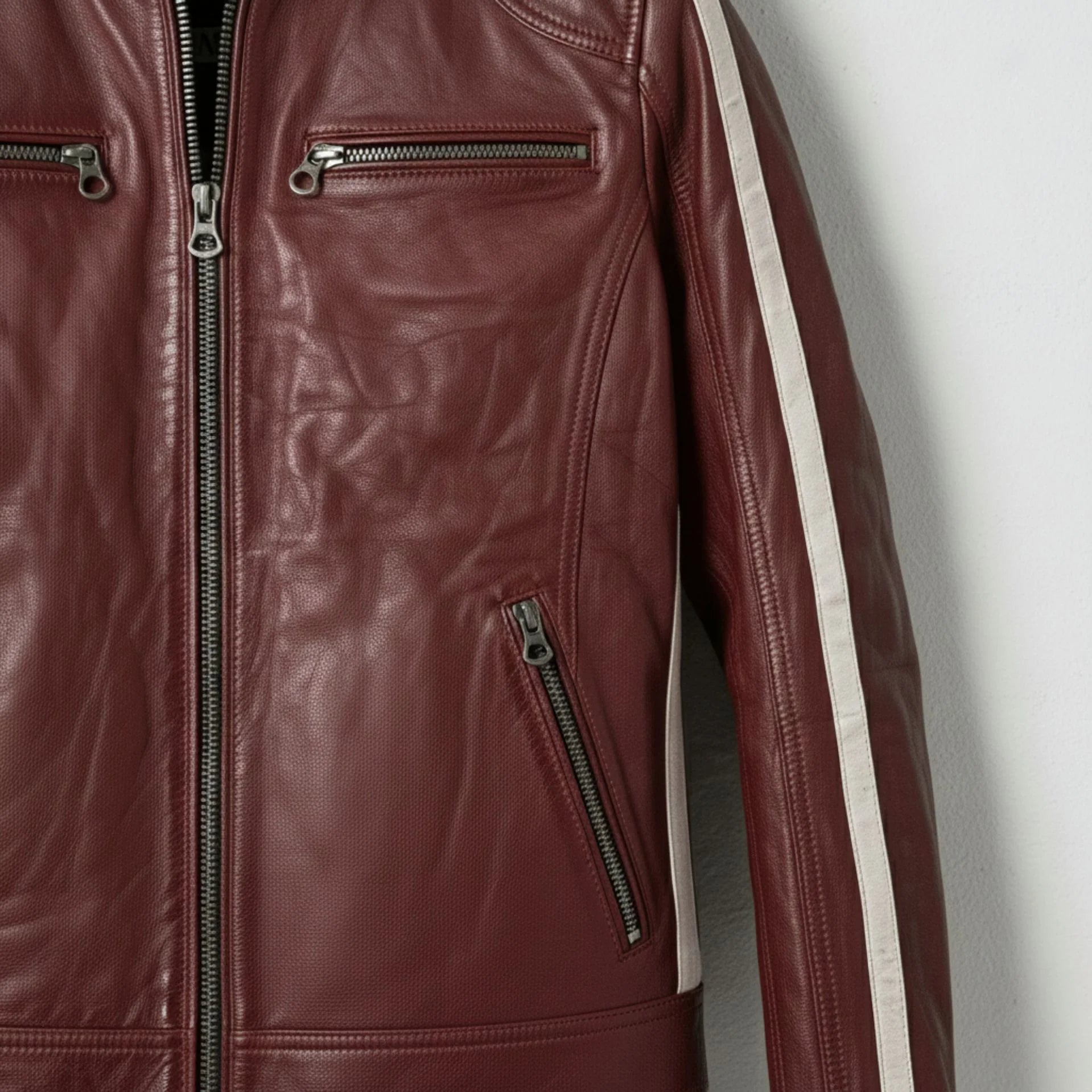 Close up of chest zipper pockets on men's red leather biker jacket.