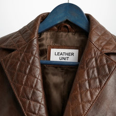 Close up of quilted lapel and Leather Unit label on brown leather blazer