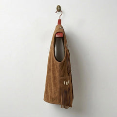 Side profile of men's tan suede fringe cowboy vest with braided edges.