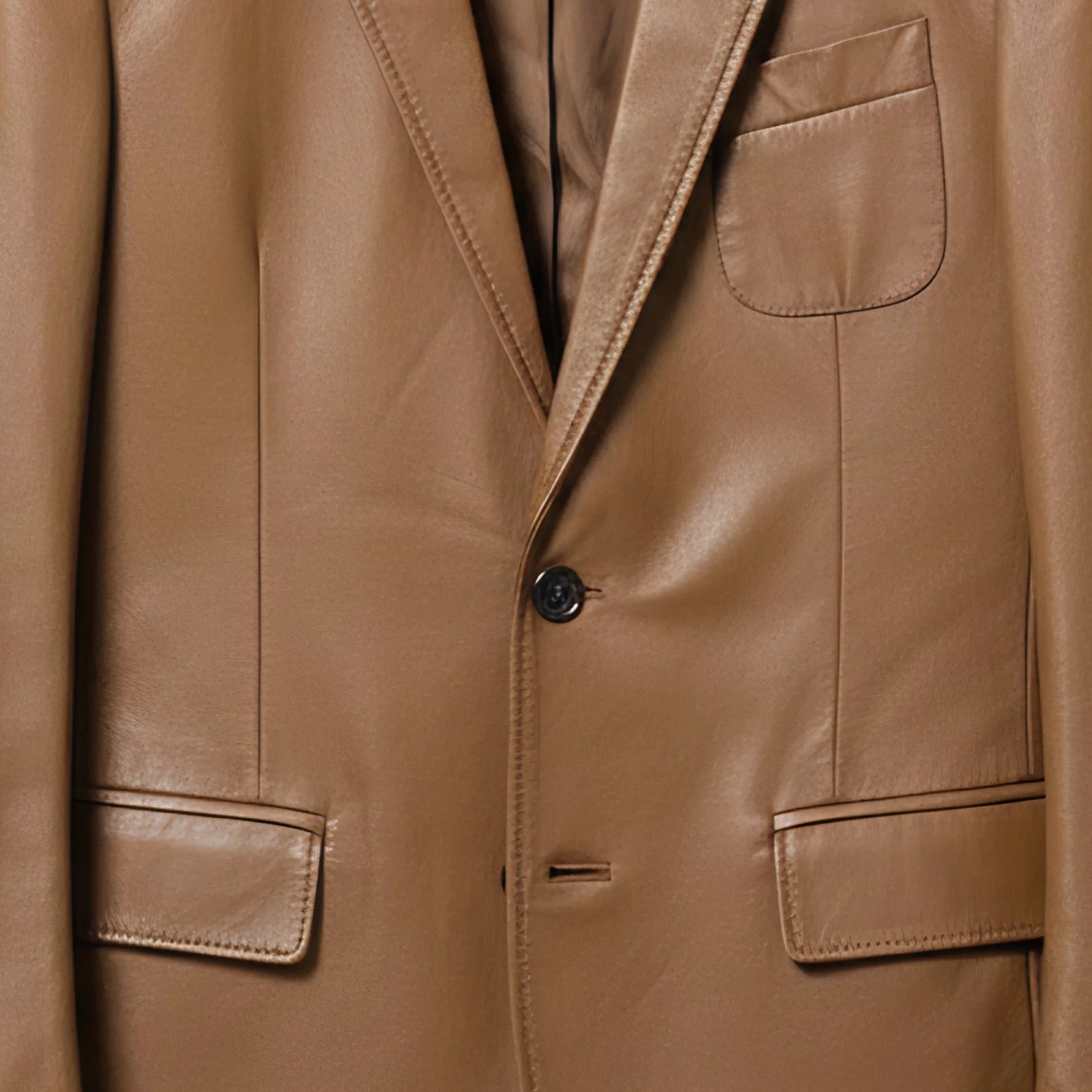 Front buttons and flap pockets on men’s brown leather sport coat