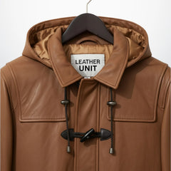 Close up of hood, collar and toggle closure on men's tan leather duffle coat.
