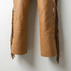 Detail of lower legs and fringe on men's tan leather cowboy chaps