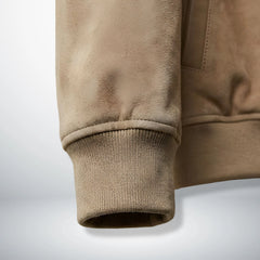Detail of ribbed cuff and suede sleeve on men's tan leather bomber jacket.