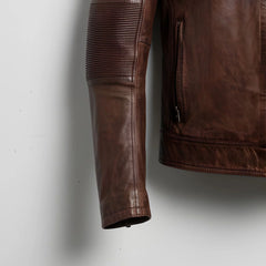 close up of ribbed elbow panel and side zip pocket on men's brown cafe racer leather jacket.