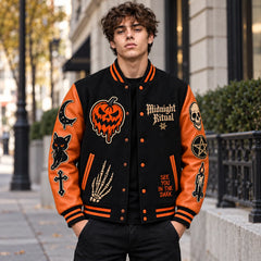 Lifestyle front view of black and burnt orange Midnight Ritual Halloween varsity jacket with embroidered occult patches