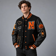 Three-quarter model view of black Halloween letterman jacket with orange accents and embroidered seasonal patches
