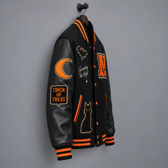 Side-angle hanging view of black Halloween varsity jacket highlighting leather sleeve, moon and Trick or Treat patches