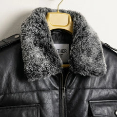 Close-up of grey faux fur collar on black leather bomber jacket