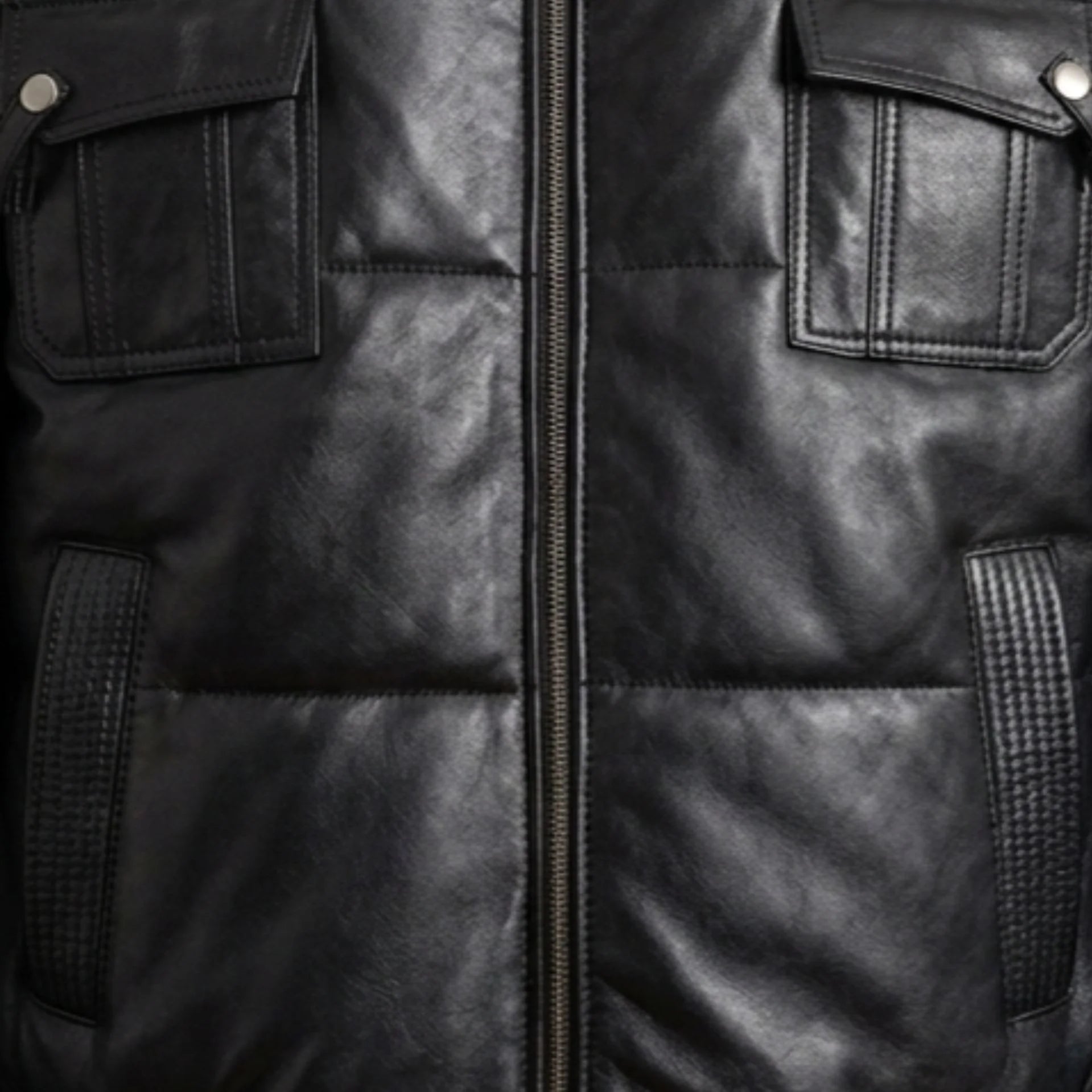 Detail of zipper and chest flap pockets on men's black puffer bomber leather jacket
